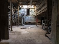 a building that has an industrial looking area with concrete flooring and exposed wall with old machinery