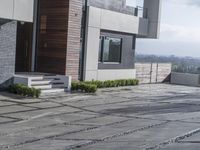 the exterior and landscape of a modern house in los angeles, california with stone and wood