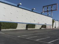 a white building with blue roof next to the street in front of it and a clock on a pole on top