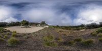 a bird's eye view of a house on a hill covered in grass and shrubs