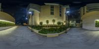 a wide angle view of a large building at night time with a clock tower near by