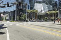 a city street with palm trees and a building in the background on a clear day