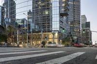 a city street with palm trees and a building in the background on a clear day