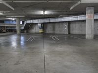 parking lot with concrete walls and stairs in the background on the floor is an empty area