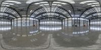 a very large and reflective building with some lights on the floor as seen through an angled circular mirror