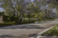 trees line the street in front of an apartment building in beverly hills, california, where police officers search homes and cars