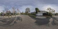 a neighborhood with residential buildings and palm trees in the foreground of it as seen from a fisheye lens