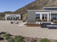 two gray homes with patio area and steps lead to the back porch of the house