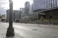 a stop sign is in the middle of an empty street with many tall buildings on either side and a lot of windows behind them