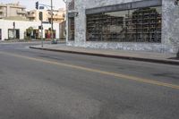 an empty street near a large building with several windows on the outside of it,