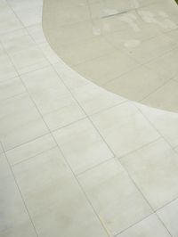 the skater in the blue jacket is skating on a circular pool deck with tile around it