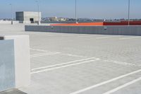 a skateboarder is on the top of the concrete ramp in the parking lot