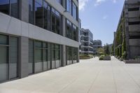 a city square has several different sized buildings and landscaping in them with glass panels along the walkway