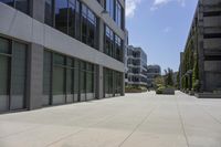 a city square has several different sized buildings and landscaping in them with glass panels along the walkway