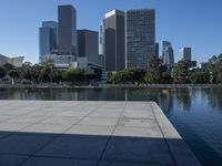 a view of some very tall buildings and a lake with a boat on the water