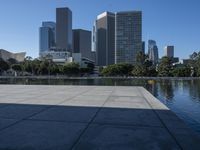 a view of some very tall buildings and a lake with a boat on the water