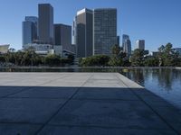 a view of some very tall buildings and a lake with a boat on the water