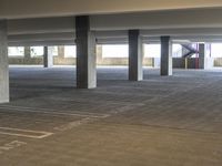 parking spaces with multiple level ramps and concrete columns, with signs on the floor in front of them