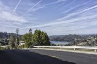 a view of a highway leading to the ocean on a sunny day in california with blue skies