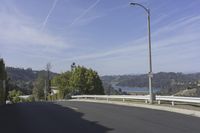 a view of a highway leading to the ocean on a sunny day in california with blue skies