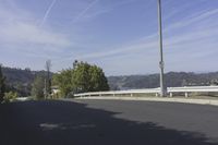 a view of a highway leading to the ocean on a sunny day in california with blue skies