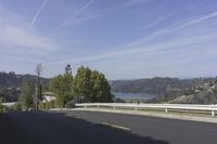 a view of a highway leading to the ocean on a sunny day in california with blue skies