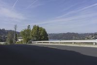 a view of a highway leading to the ocean on a sunny day in california with blue skies