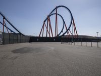 the roller coaster on display sits in an empty parking lot outside of the amusement park