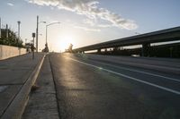 the sun shining in front of a freeway at dusk over highway level with traffic on it