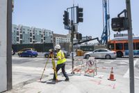 a construction worker on a city street with traffic lights, markers and a crosswalk