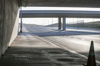 a highway with two lanes leading towards a freeway below a bridge between the roadway and the highway