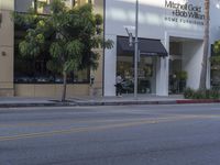 a building is shown behind a man riding his skateboard down the street while holding on to his skateboard