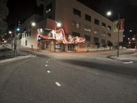 an empty street near the building with its neon sign in front of it at night