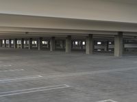 a large open parking garage with a bench in it's center area for people to walk through