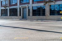 a sign in front of a commercial building on an open road with a sign pointing out the windows and there are no people