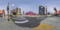 a city intersection has a huge red object on the curb near a stoplight and a traffic light