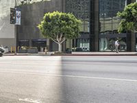 a young man rides his bike on the street in front of the city hall at sunset