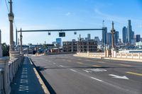 a picture of the city and an intersection on a busy city street, one way traffic signal with traffic in view