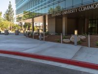 two grey blocks sitting next to a tall building on a sidewalk in front of grass