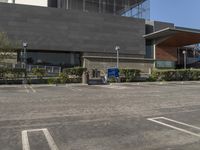 a parking lot with a shopping trolley parked in front of it and a building across from