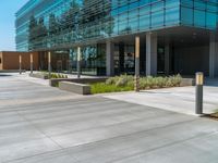 two grey blocks sitting next to a tall building on a sidewalk in front of grass