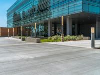 two grey blocks sitting next to a tall building on a sidewalk in front of grass