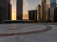 the setting sun illuminates a large circle on a concrete ground with a clock tower at top