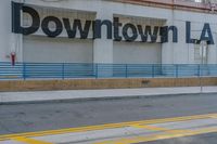 the storefront of downtown l a is painted brown with blue lines on a sunny day