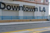 the storefront of downtown l a is painted brown with blue lines on a sunny day