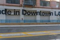 the storefront of downtown l a is painted brown with blue lines on a sunny day