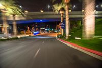 a blurry street is seen on the pavement at night while the lights are blue