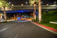 a blurry street is seen on the pavement at night while the lights are blue