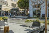 some benches on a city street and buildings with people walking by them to work at their desks