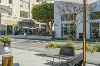 some benches on a city street and buildings with people walking by them to work at their desks